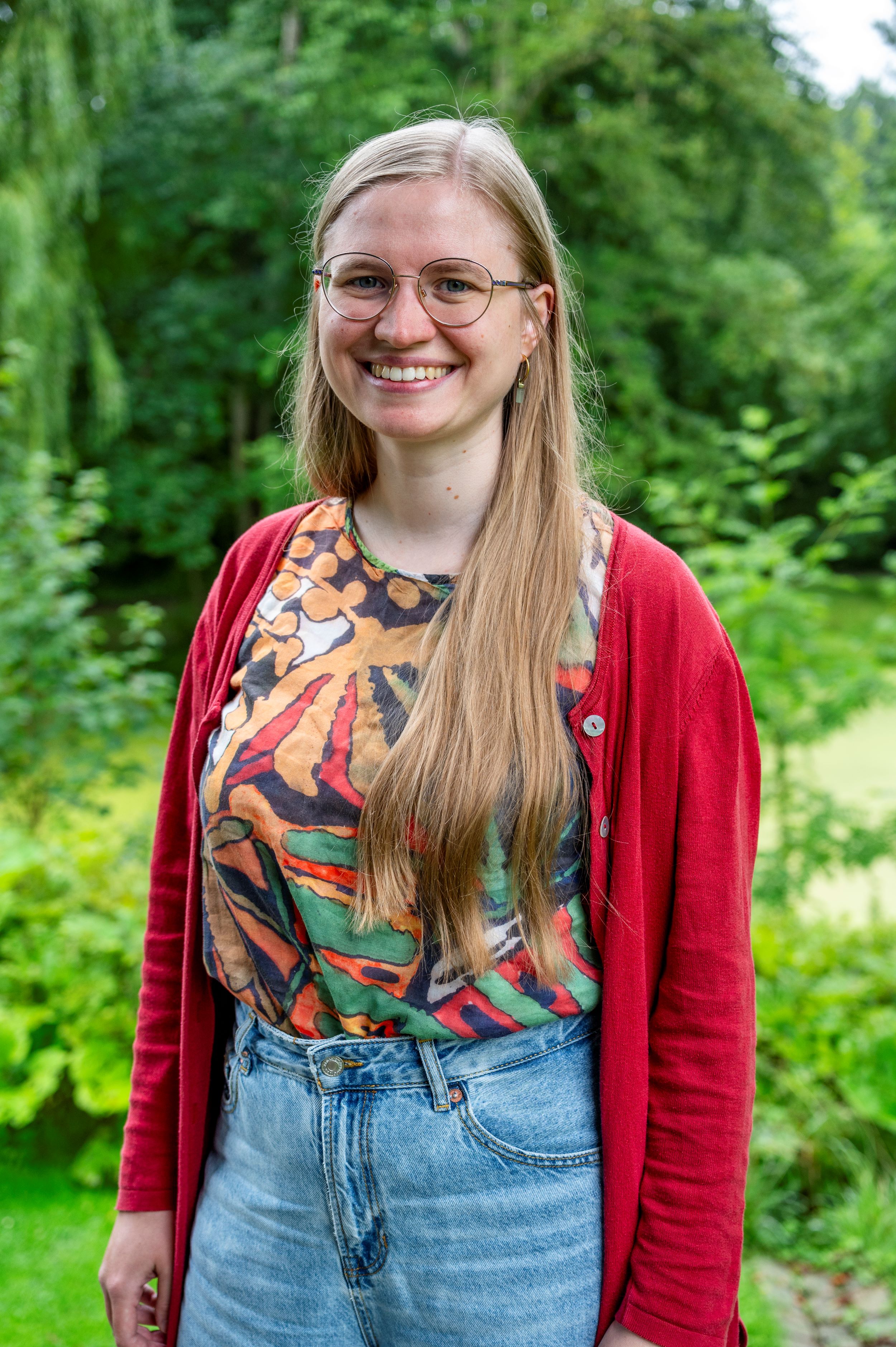 Foto einer Frau in roter Strickjacke mit langen Haaren.