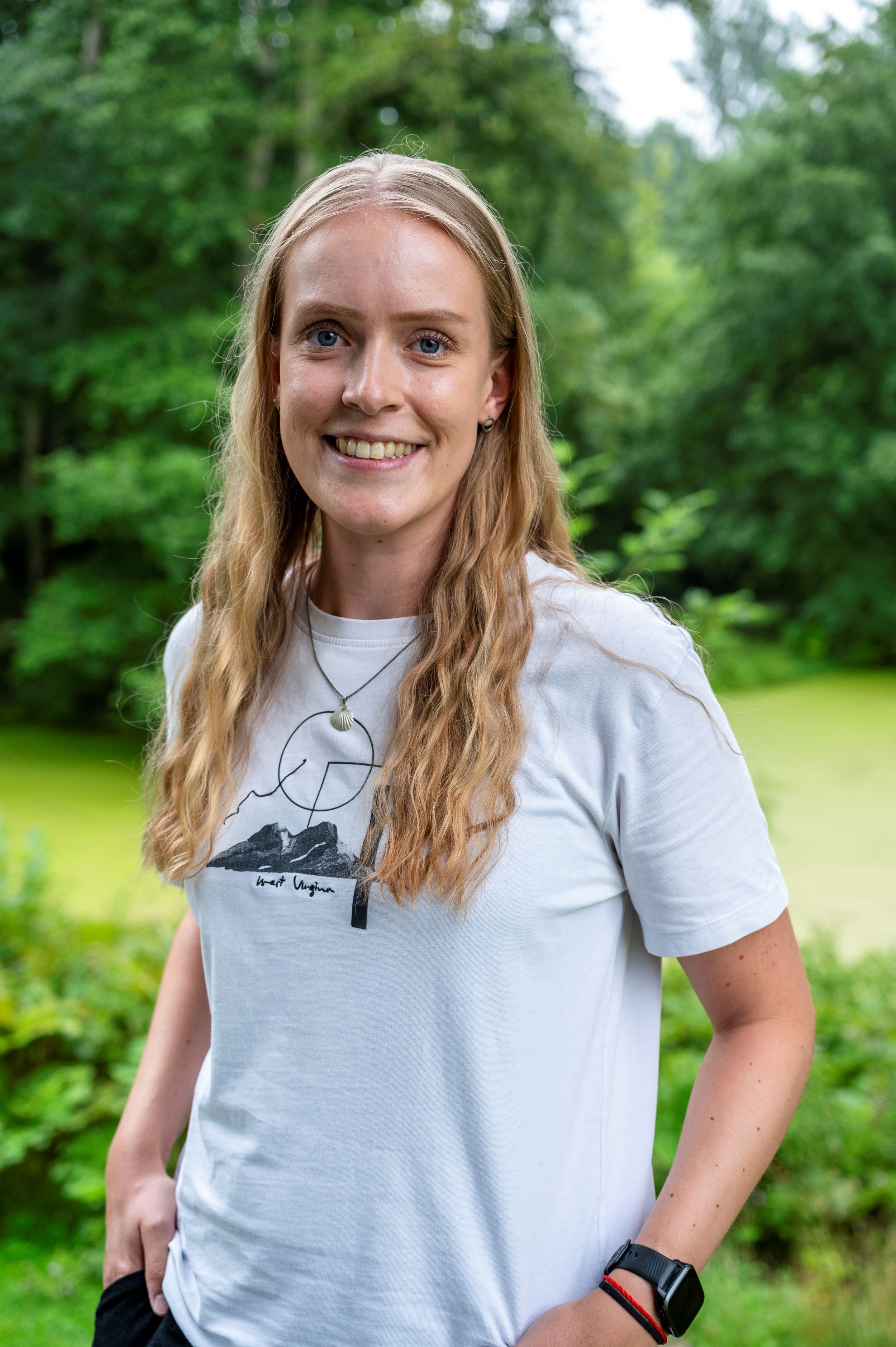 Foto einer Frau mit hellen Haaren und weißen T-Shirt.